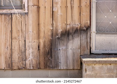 Close Up Of Weathered Wood Siding Beginning To Rot Around Front Step Of Cottage Or House