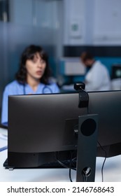 Close Up Of Webcam On Modern Computer For Video Call And Remote Communication In Office. Nurse Using Camera On Monitor For Video Conference And Online Telemedicine, Working Late At Night.