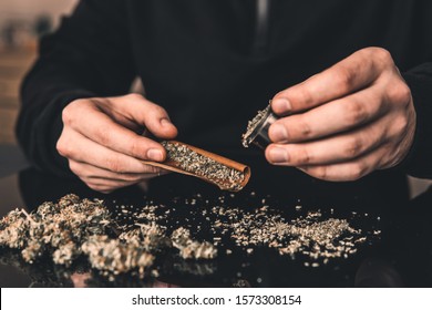 Close Up Weed Joint With Lighter. Smoke Pot Person. Man Rolling Cannabis Blunt. Rolling A Marijuana Weed Joint .