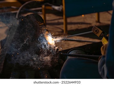 Close up of welding sparks and smoke from metal work done on steel industrial parts. (Construction sites of India - Tamil Nadu) - Powered by Shutterstock