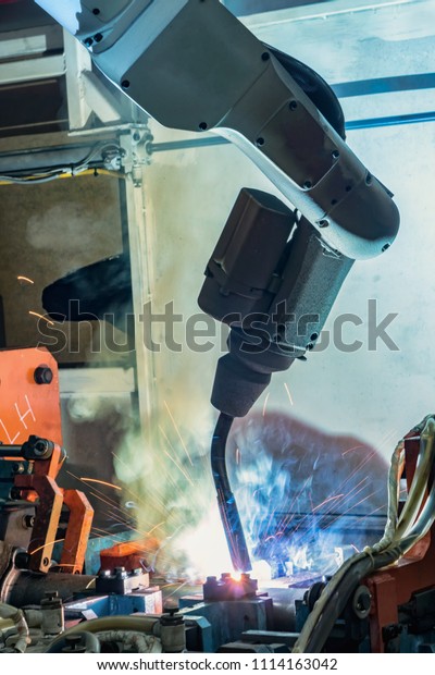 Close up welding torch\
of robot welder.