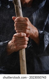 Close Up Of Wet Hands Elderly Woman Holding Walking Stick. Falling Raindrops On Hands. Selective Focus On Hands Wrinkled Skin.