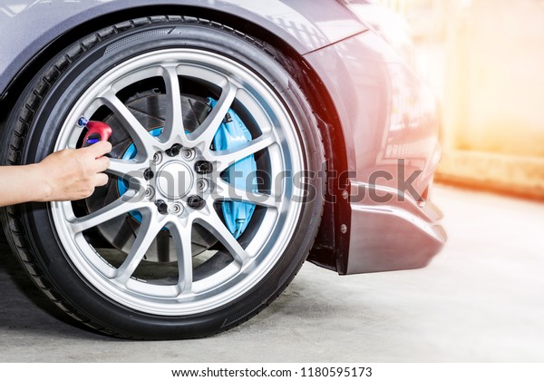 Close\
up wheel racing car and hand a man with Tire digital gauge check\
air pressure on car  basic maintenance by\
oneself