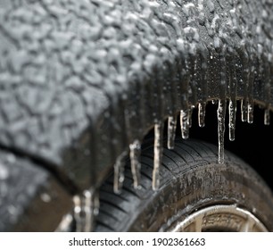 Close up of wheel well of car during sleet and cold weather. Icicles forming. 