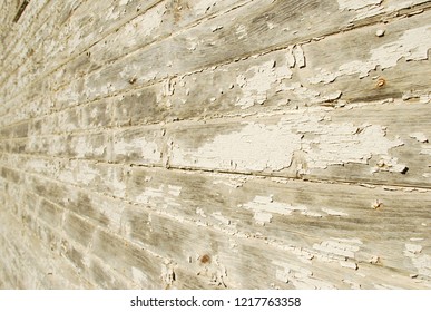 A close up of a while, peeling paint, old wooden building, rusty nails.