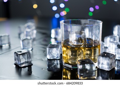 Close Up Whiskey In Glass With Ice Cubes.dark Black Background.