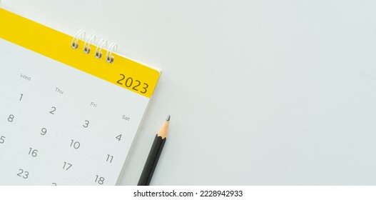close up white calendar 2023 month schedule with pencil to make appointment meeting or manage timetable each day lay on white background for planning work and life concept - Shutterstock ID 2228942933