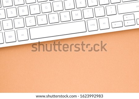 Close up white computer keyboard on brown background. View from above.