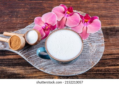 Close up white cup of salep milky hot drink on wooden background. Cup of salep milky traditional hot drink of Turkey with cinnamon served in a porcelain cup.