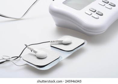 Close up of white electrodes and electrical muscle or nerve stimulation device