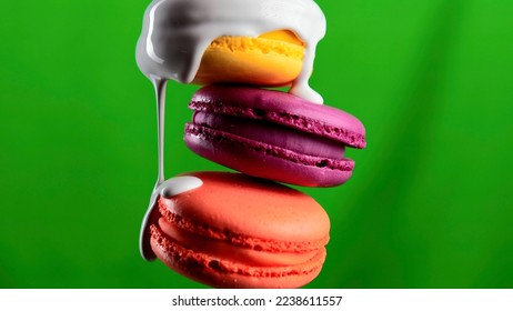 Close up of white glaze draining down the three macarons on a colorful wall background. Stock clip. Sweet food porn concept.
