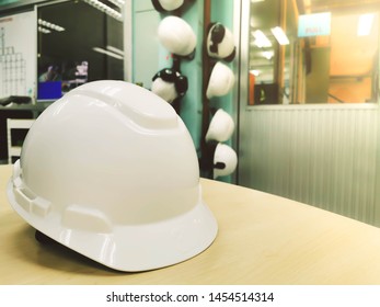 Close Up White Hard Safety Helmet Hat On Wooden Work Desk For Safety First In Plant Work Of Engineer.