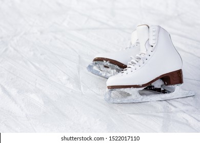 close up of white leather figure skates and copy space over ice background with marks from skating