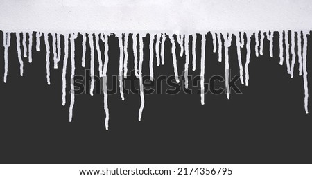 close up of white paint leaking down black background