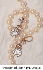 Close Up Of White Pearl Necklace On An Ivory Fabric With Vintage Gold Earrings - Regency Fashion Inspiration