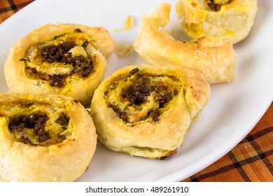 Close Up Of White Plate With Fresh Baked Beef Pumpkin Pinwheels.