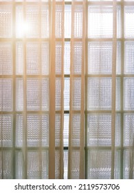 Close Up White Sheer Curtain With Clear Glass Block Wall And Morning Sunlight Effect From Outside.