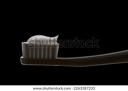 Close up of white toothbrush with toothpaste isolated on black background