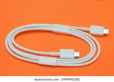 close up of white USB type-c cable on orange background. - Powered by Shutterstock