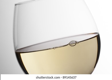 Close Up Of White Wine Glass In A White Degraded Background.