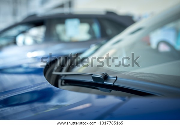 Close up of A\
windscreen wiper or windshield wiper is a device used to remove\
rain, snow, ice and debris from a windscreen or windshield. , New\
cars parked in the\
showroom