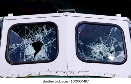 Close up of the windshield of a boat  with broken glass in both windows