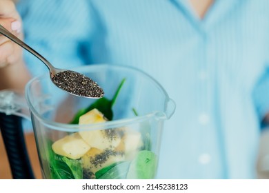 Close up woman adding chia seeds during making smoothie in the kitchen. Superfood supplement. Healthy detox vegan diet. Healthy dieting eating, weight loss program. Selective focus. Copy space.