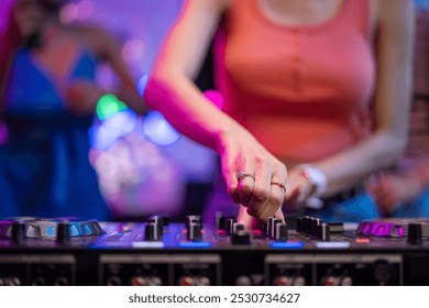 Close up of woman artist DJ mixing and scratching music mixer controller. Attractive female musician DJ having fun mixing music on console touching buttons and playing electronic music at neon party. - Powered by Shutterstock