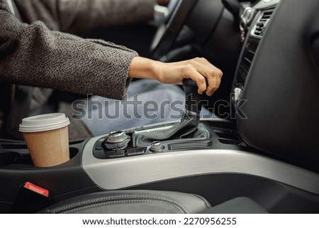 Close up of woman change speed holding hand on gearbox in the car
