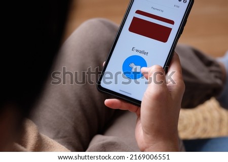 close up woman choose payment online on shopping mobile app on sofa at home