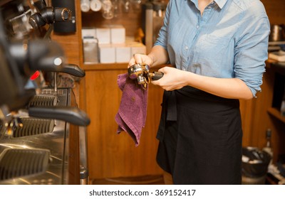 close up of woman cleaning espresso machine holder - Powered by Shutterstock