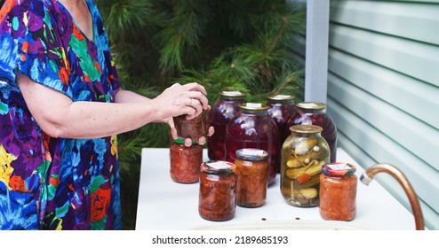 Close Up Of Woman Closing Lid On Jar Of Homemade Canning Jam