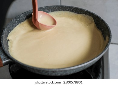 Close up of woman cooking in kitchen at home and frying pancakes on modern stove, preparing pancakes. - Powered by Shutterstock