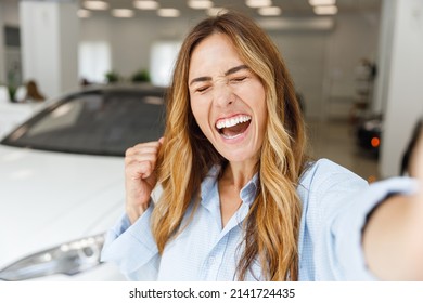 Close Up Woman Customer Buyer Client In Blue Shirt Do Selfie Shot Pov Mobile Phone Do Winner Gesture Choose Auto Want To Buy New Automobile In Car Showroom Vehicle Salon Dealership Store Show Indoor