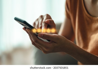 Close up of woman customer giving a five star rating on smartphone. Review, Service rating, satisfaction, Customer service experience and satisfaction survey concept. - Shutterstock ID 2037501851