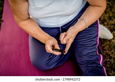 Close Up Of Woman With Diabetes Checking Her Blood Glucose 