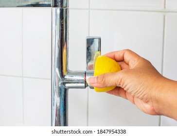close up a woman doing housework using lemon tricks using lemon juice as a natural detergent to clean sink faucet in the kitchen. 