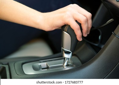 Close Up Of Woman Driver Holding Her Hand On Automatic Gear Shift Stick Driving As Car.