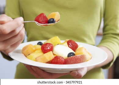 Close Up Of Woman Eating Bowl Of Fresh Fruit