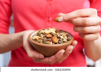 Close Up Of Woman Eating Bowl Of Healthy Nuts And Seeds