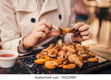 Close Up Of Woman Eating Chicken Wings.