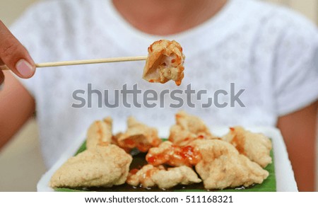 close up of woman eating fried meatball, focus at holding meatball