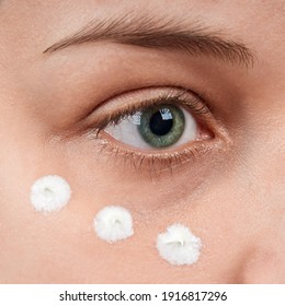 Close Up Of Woman Eye With Cream Under Eyes. Isolate On Gray Background.