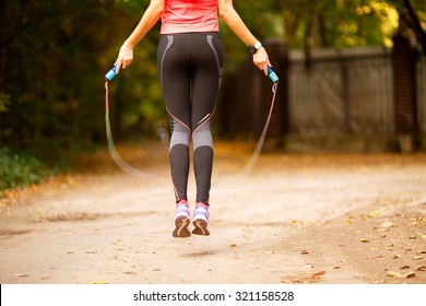 Close up of woman feet jumping, using skipping rope in park