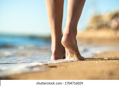 Close Up Of Woman Feet Walking Barefoot On Sand Beach In Sea Water. Vacation, Travel And Freedom Concept. People Relaxing In Summer.