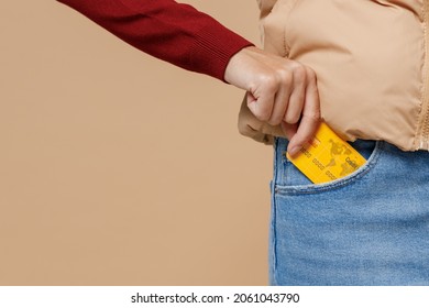 Close Up Woman Female Caucasian Hand Arm Put Credit Bank Card Into Denim Jeans Pocket Pants Isolated On Plain Pastel Beige Background Studio Portrait. People Lifestyle Achievement Wealth Concept.