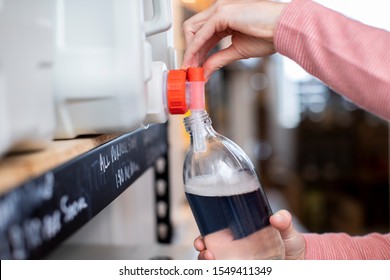 Close Up Of Woman Filling Container With Cleaning Product In Plastic Free Grocery Store