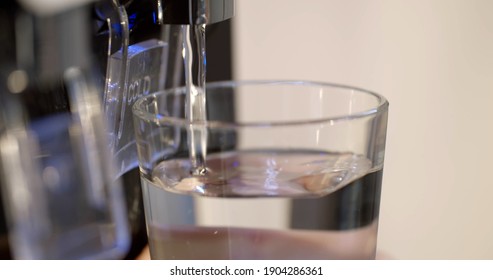 Close Up Of Woman Filling Glass With Modern Water Cooler. Cropped Shot Of Person Hand Holding Glass And Pushing Cold Button On Water Cooler