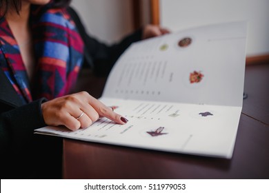 close up of woman finger with menu choosing dishes at restaurant - Shutterstock ID 511979053
