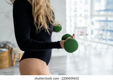 Close Up Of Woman Flexing Arms Holding Dumbbell At Home. Young Fitness Instructor Female Wearing In Black Sportswear Posing In Studio With Weights. Sport, Fitness, Athletic, Helth And People Concept.